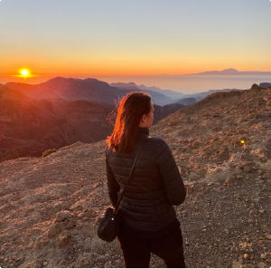 A girl looking at beautiful sunset and view from Roque Nublo in Gran Canaria